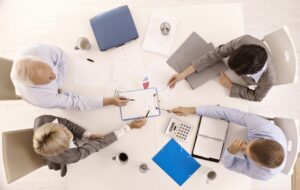 Committee of four people meeting. Overhead perspective. 